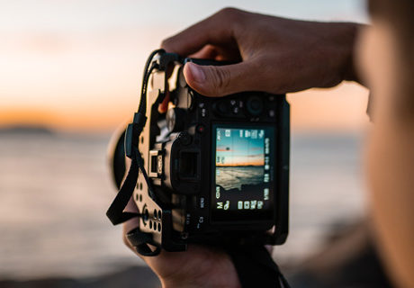photographer with camera facing the beach